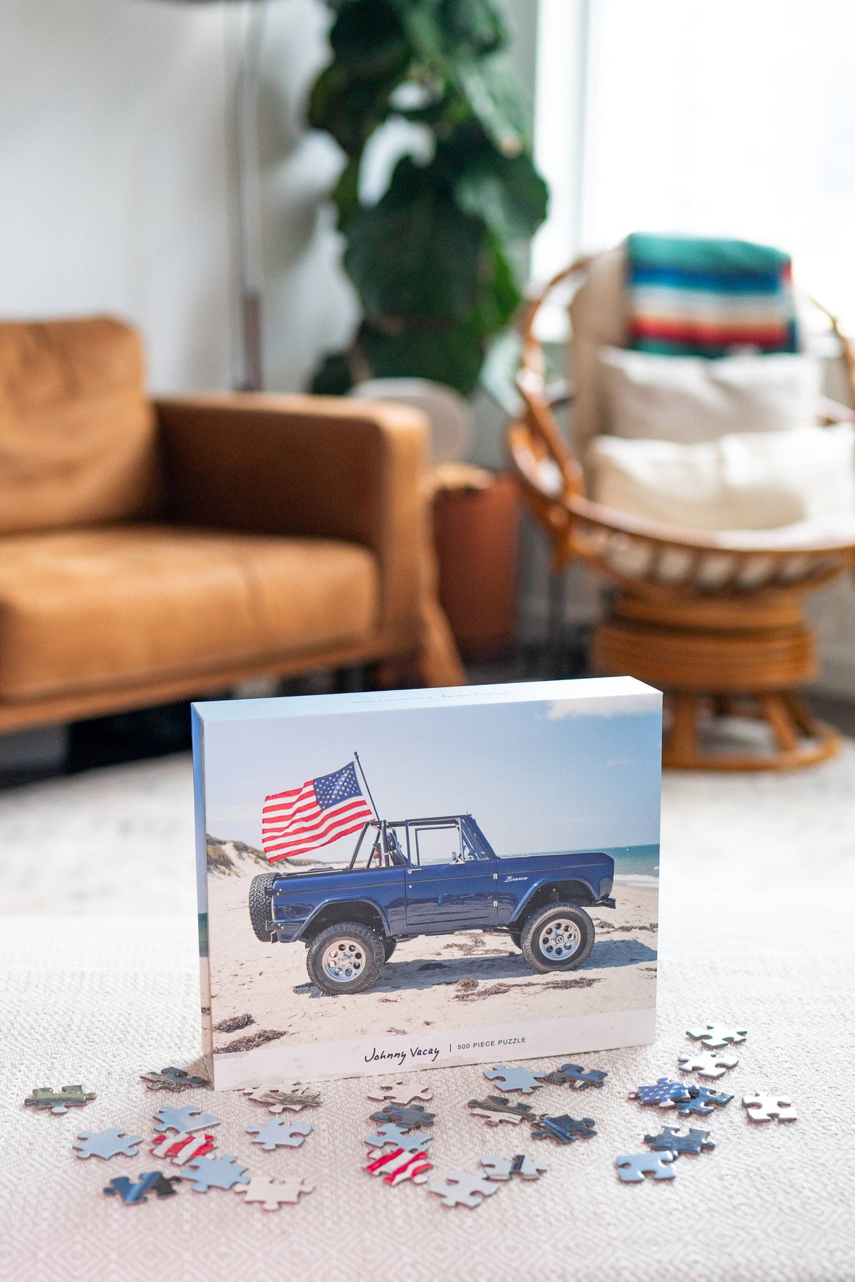 The Copper Shed American Bronco 500 piece puzzle box featuring a blue vintage SUV with a US flag on a sandy beach.