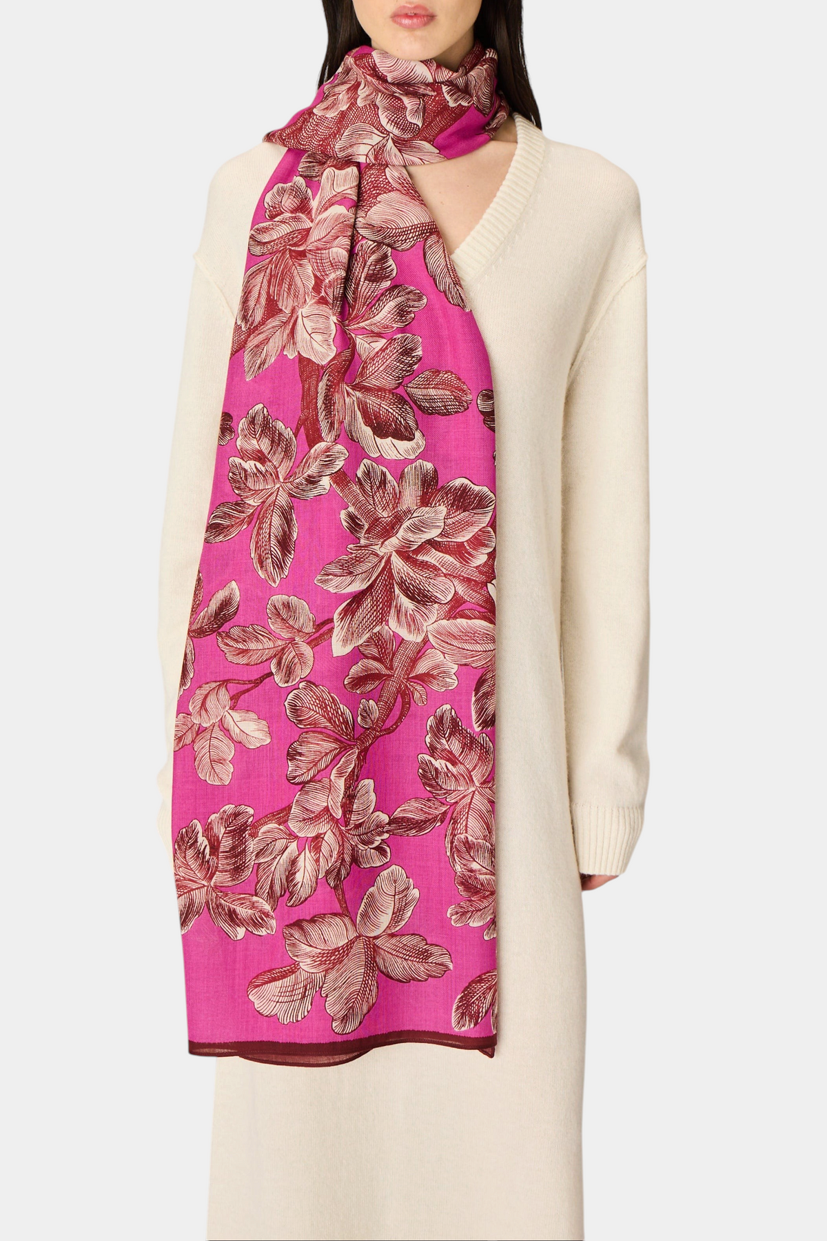 The Copper Shed Arboris fuchsia wool scarf with a floral botanical print draped over a cream sweater