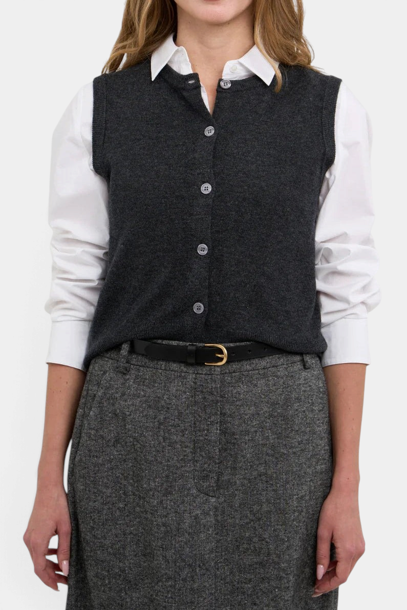 The Copper Shed Avery charcoal grey merino wool button-front sleeveless sweater vest worn over a white shirt.