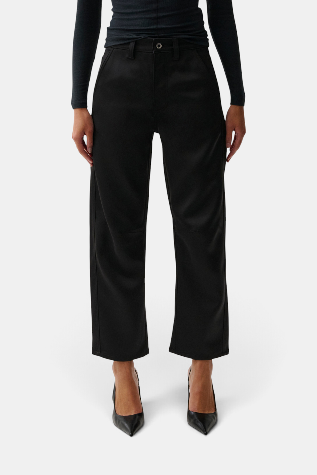 The Copper Shed Beau black sateen cropped pants with seamed crescent leg detail worn by a model.