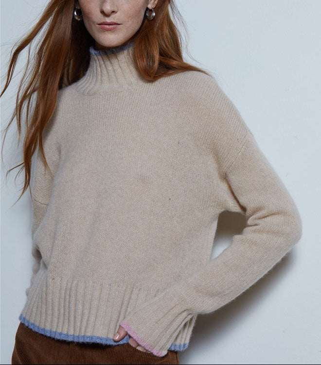The Copper Shed beige mockneck sweater with blue and pink contrast tipping on the ribbed hem and cuffs