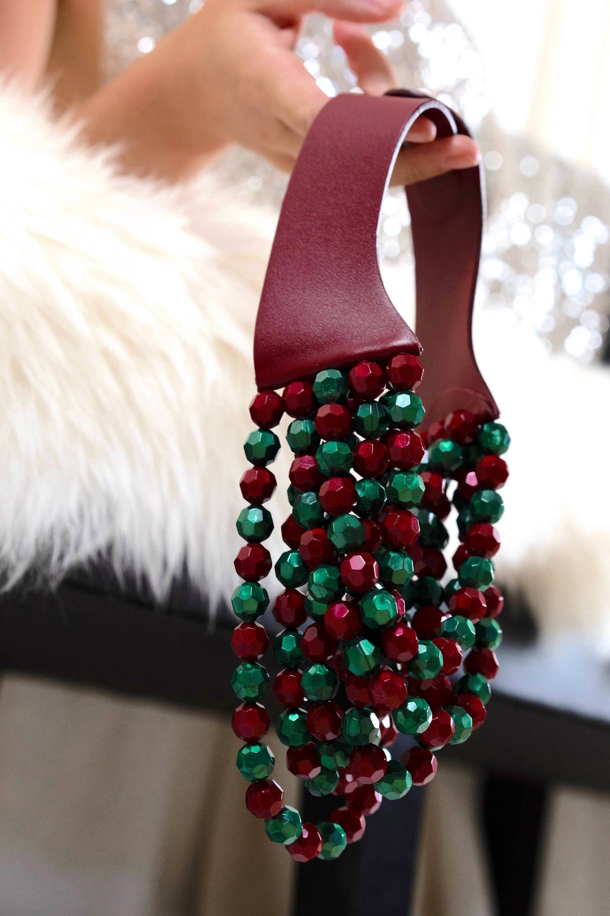 The Copper Shed Bella novelty necklace featuring layered red and green resin beads on a burgundy leather collar.