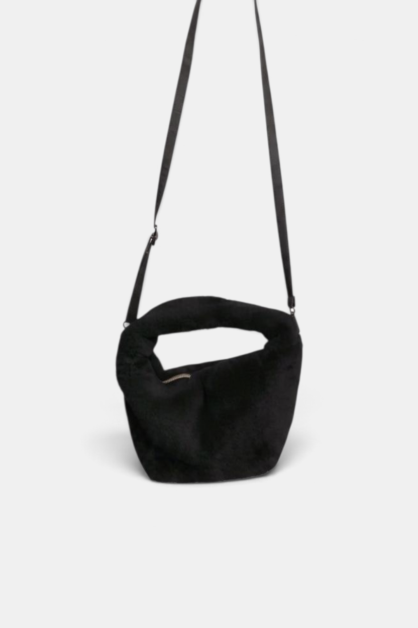 The Copper Shed black faux fur crossbody bag with a zipper closure and adjustable shoulder strap.
