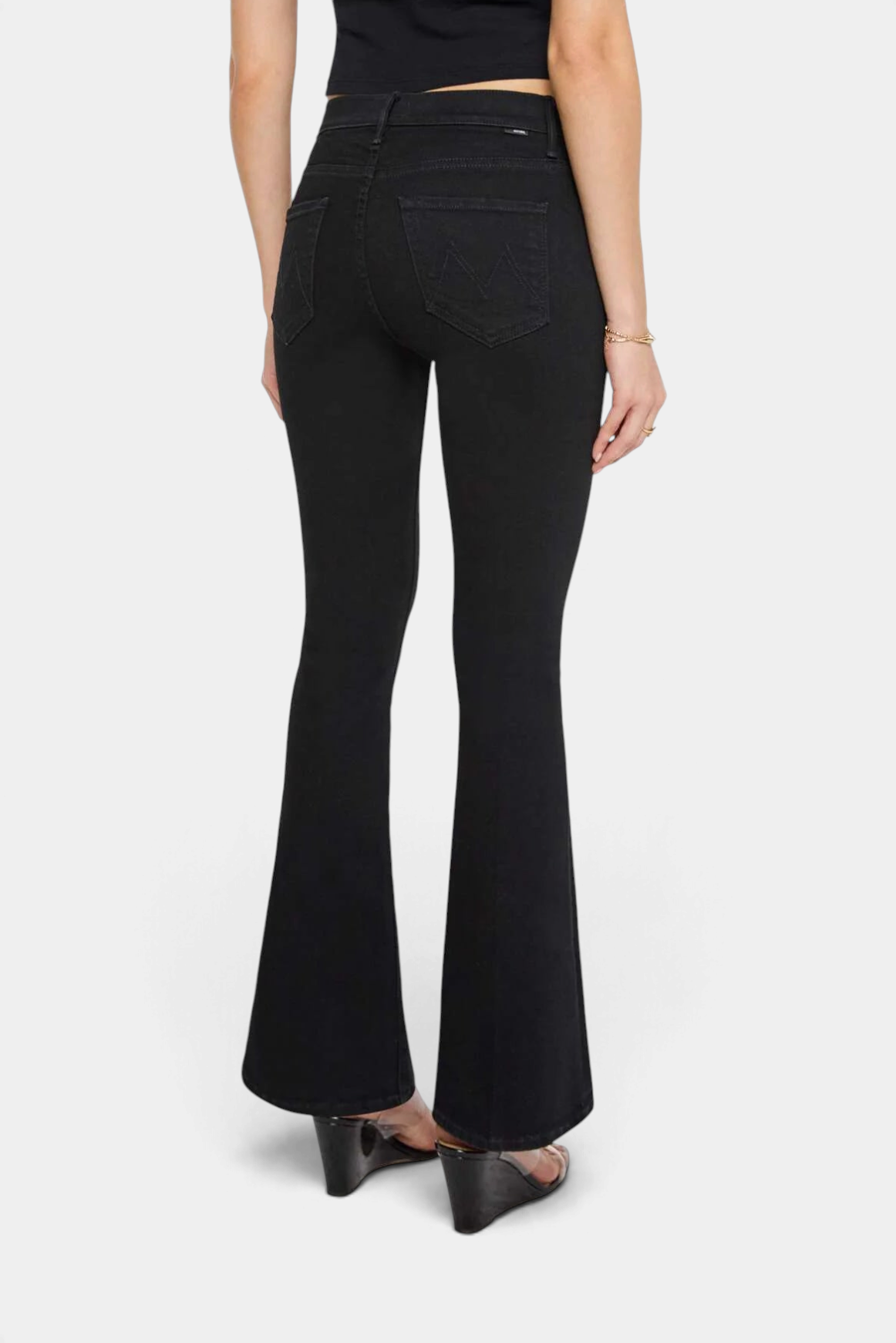 The Copper Shed The Weekender mid-rise black flare jeans with a clean hem, shown from the back on a model.
