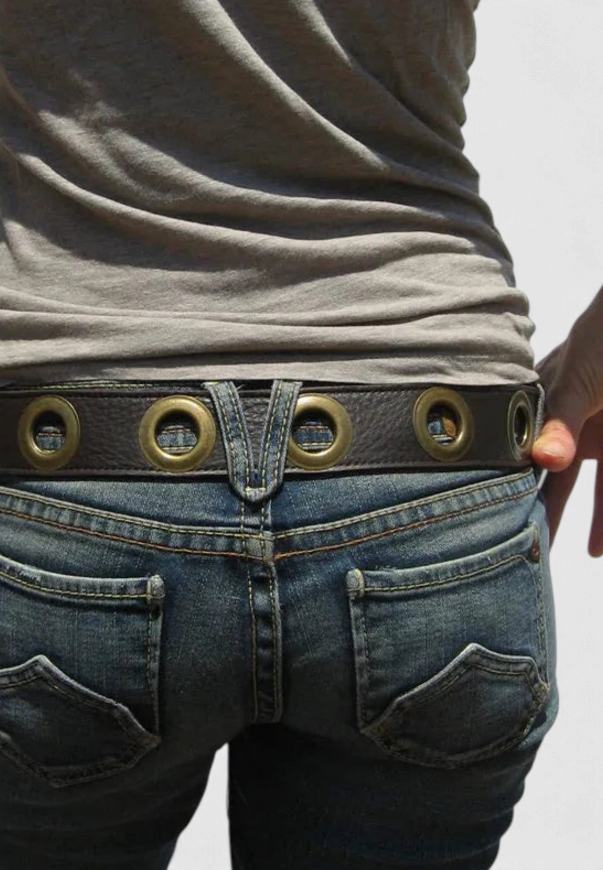 The Copper Shed black leather belt with large gold grommets and burgundy suede backing worn with blue jeans