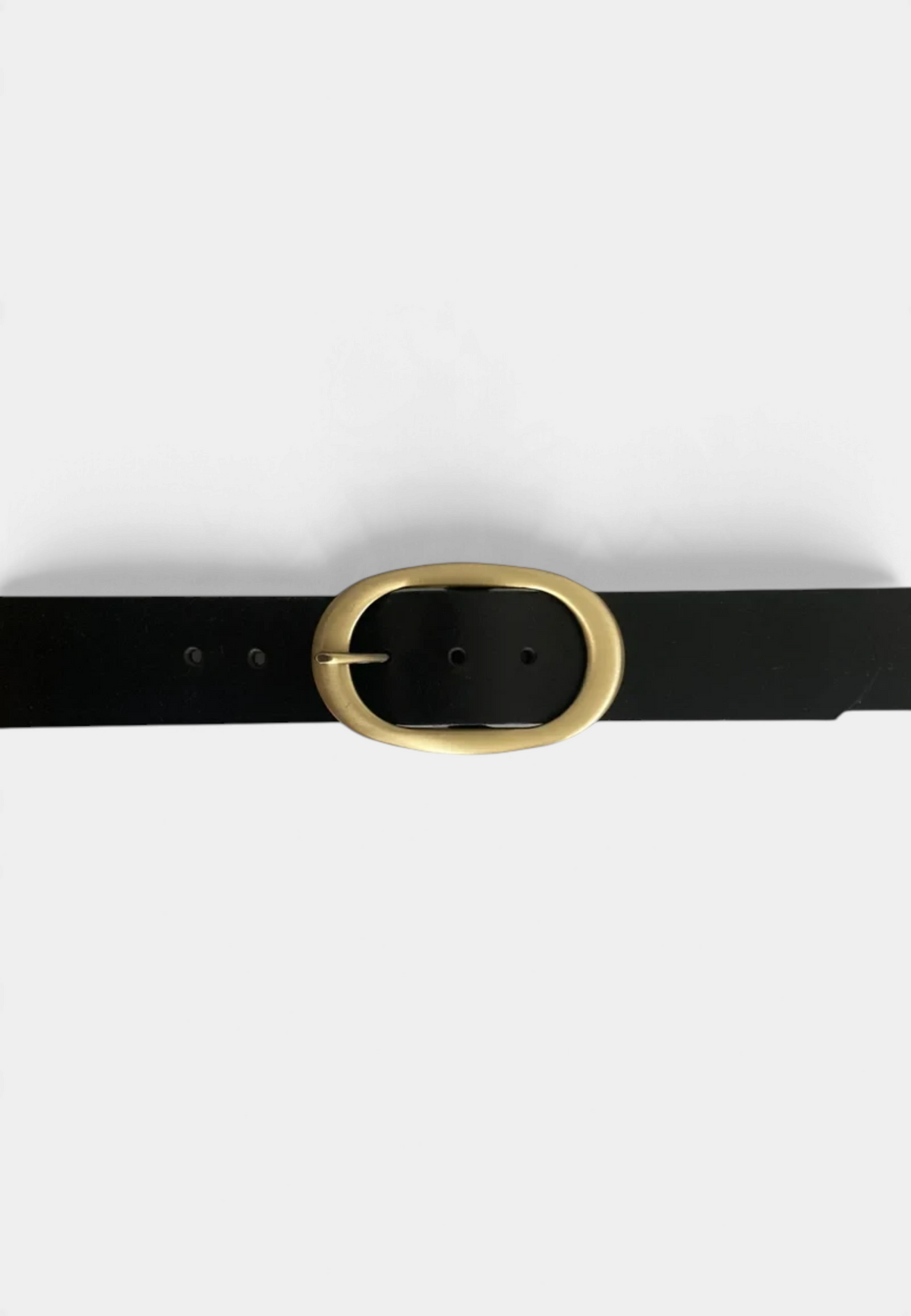 The Copper Shed black leather belt featuring an elongated antique brass oval buckle on a white background