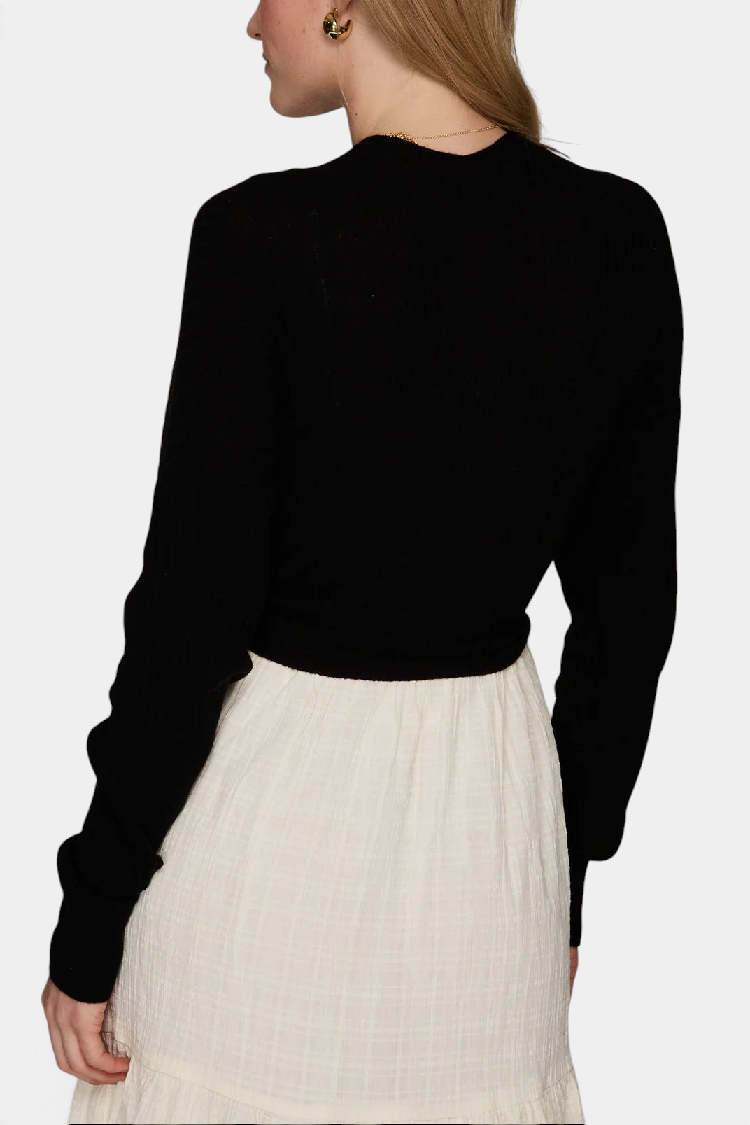 The Copper Shed black ribbed cashmere cardigan worn by a model, back view showing long sleeves and cropped fit