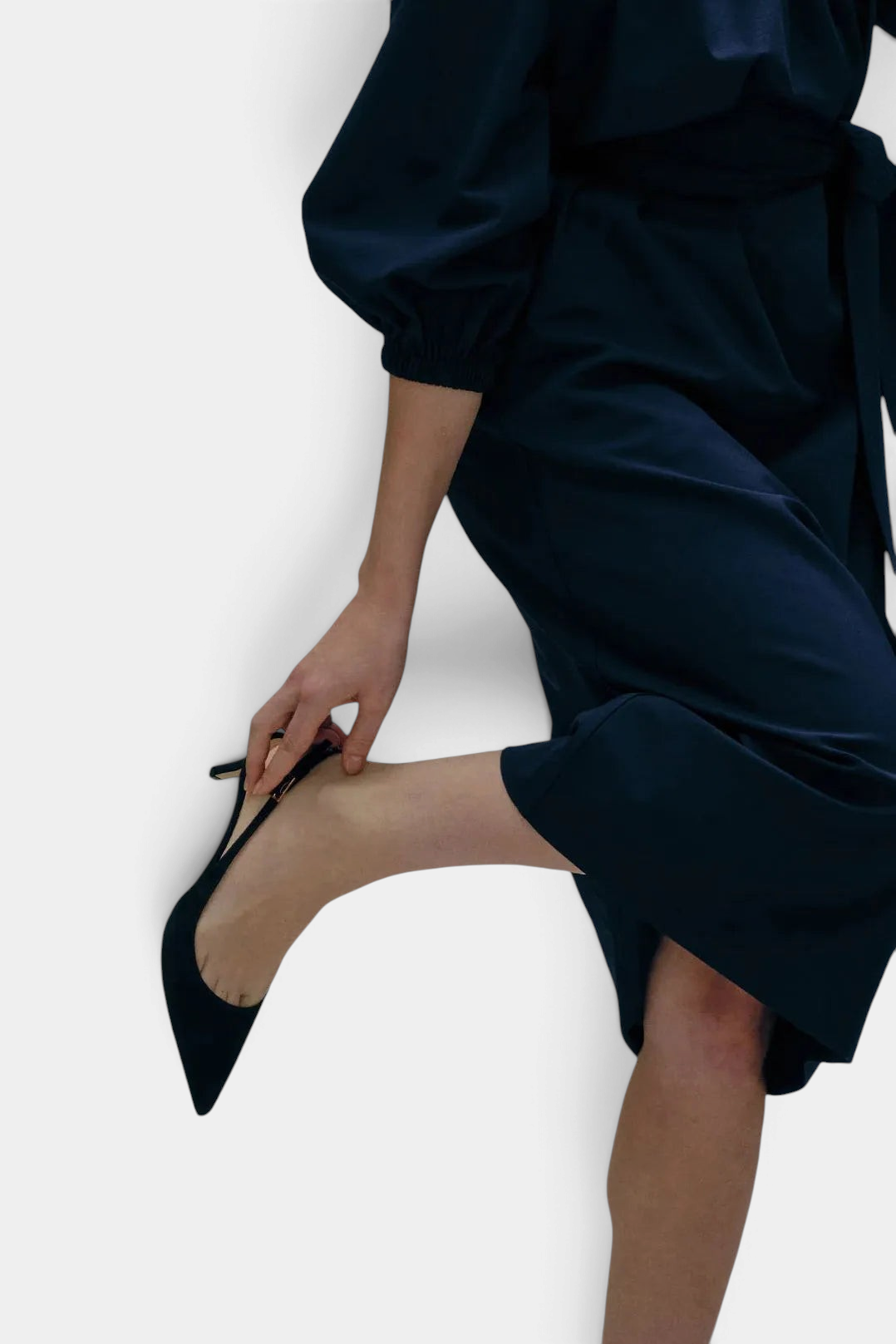 The Copper Shed black kid suede kitten heel slingback with a pointed toe and 50mm covered heel worn by a model.