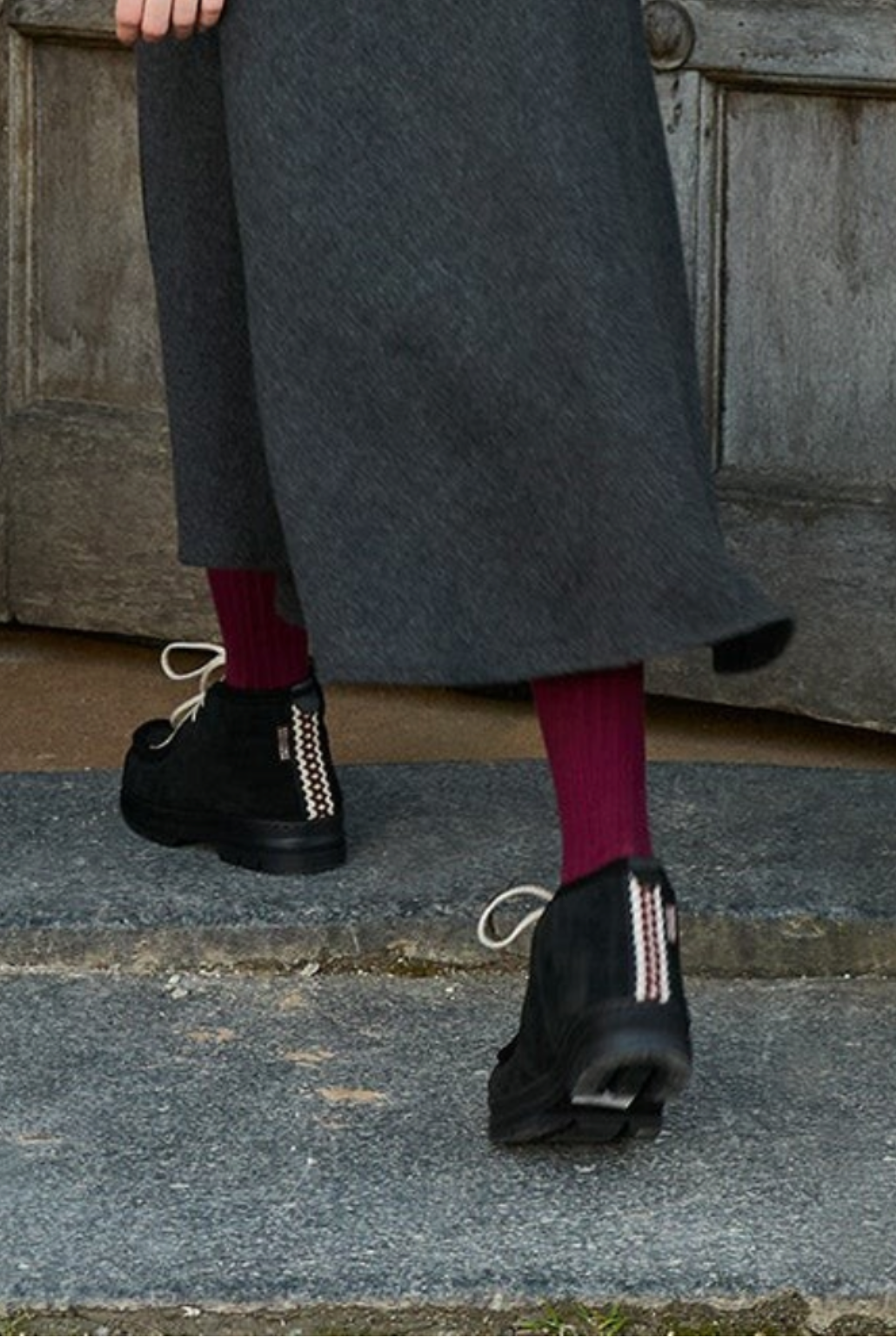 The Copper Shed black suede shearling-lined boots with folk trim heel detail worn with a grey skirt and red tights