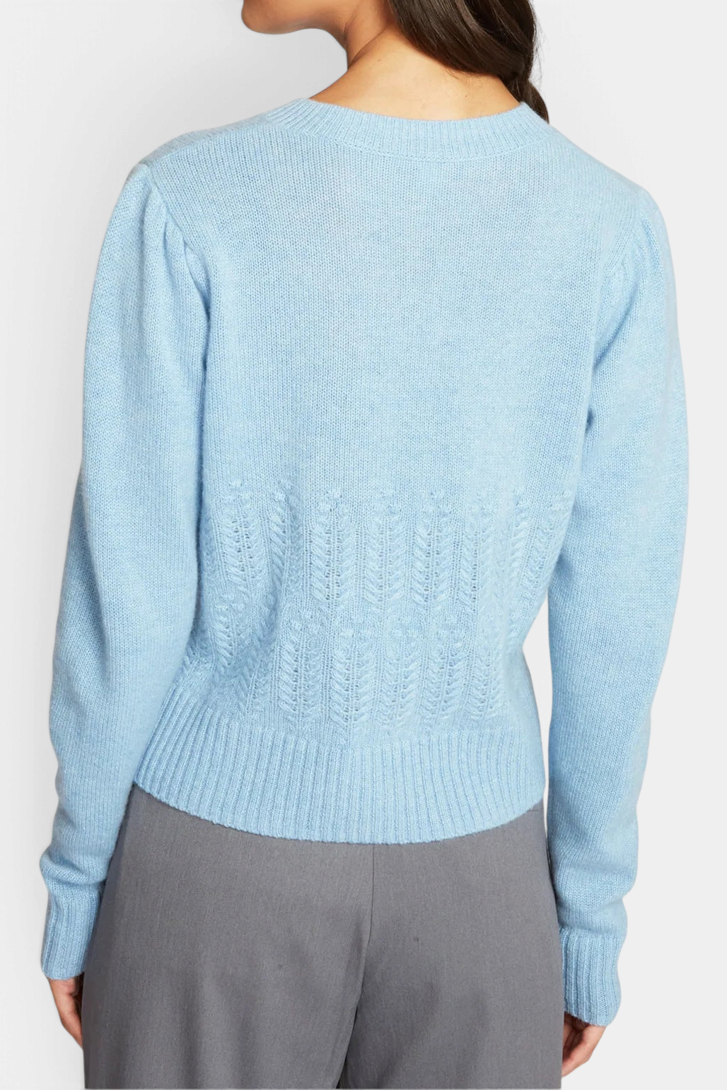 The Copper Shed heather blue cashmere cardigan with puff sleeves and popcorn stitch detail, back view on a model.
