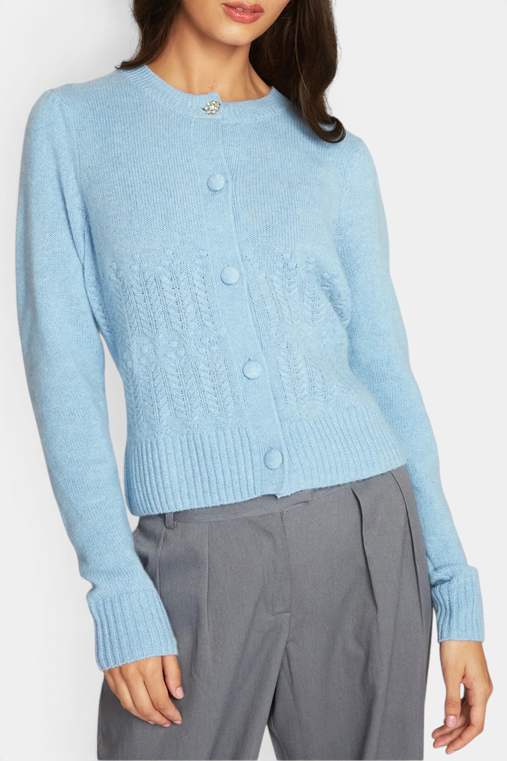 The Copper Shed heather blue cashmere cardigan with popcorn stitch, puff sleeves, and a crystal button at the neck.
