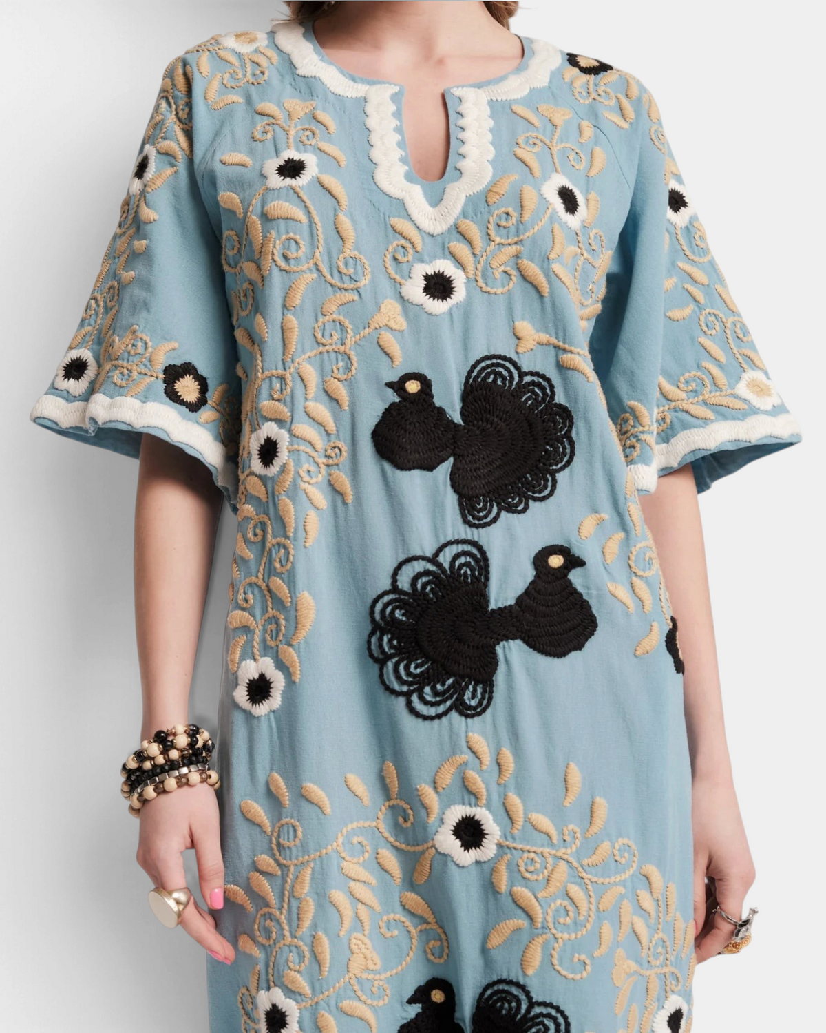 The Copper Shed light blue cotton maxi caftan with intricate black and beige peacock embroidery and bell sleeves.