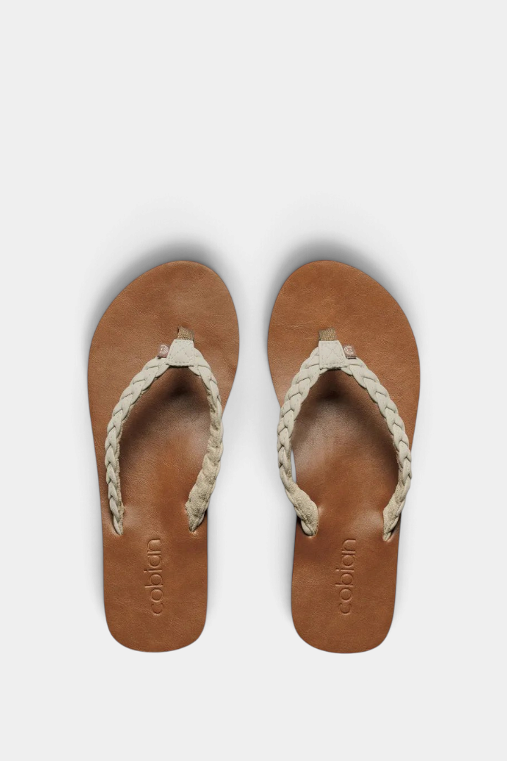 The Copper Shed Braided Pacifica flip flops with tan synthetic leather soles and cream braided straps.