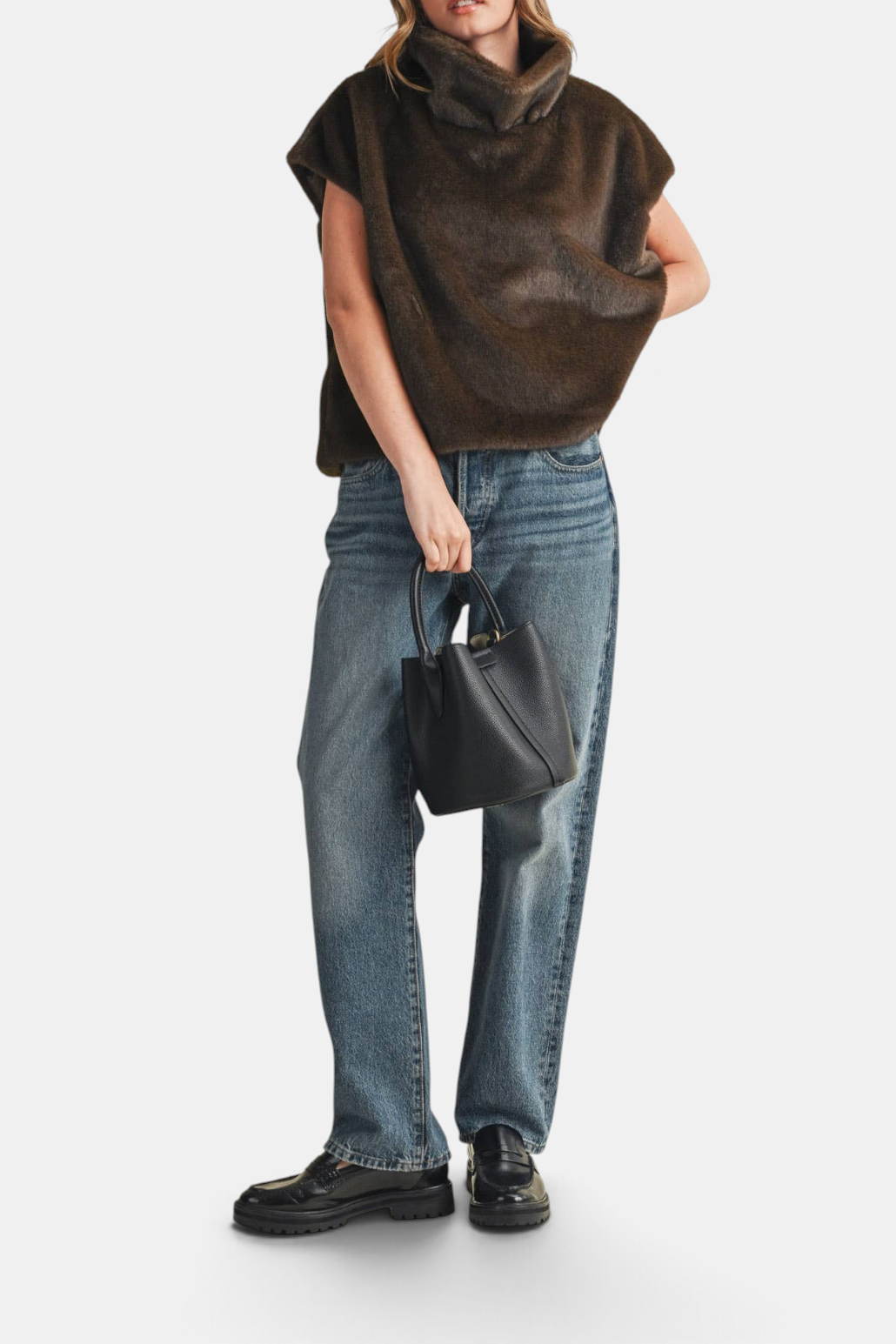Model wearing The Copper Shed brown faux fur cap sleeve turtleneck top with blue jeans and black loafers