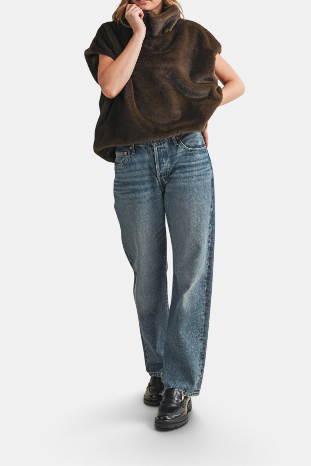 Model wearing The Copper Shed brown faux fur cap sleeve turtleneck top with blue jeans and black loafers