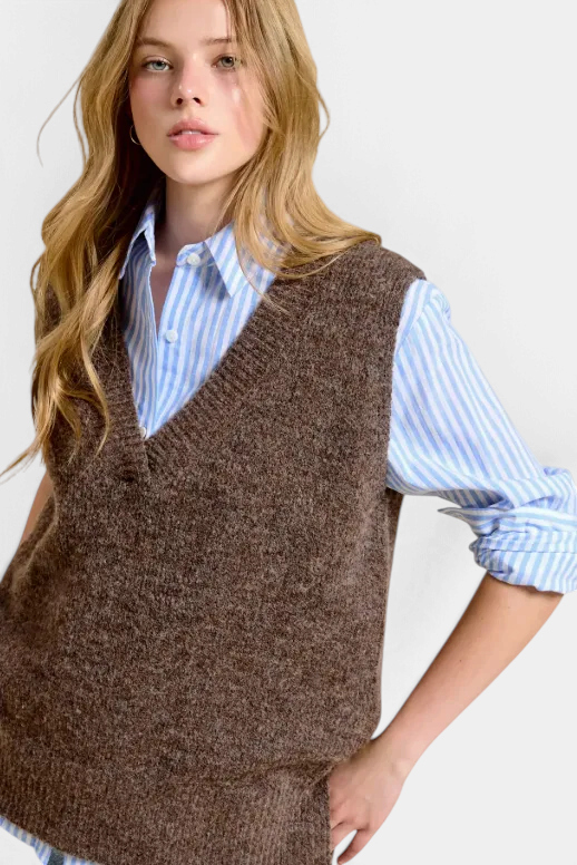 The Copper Shed brown oversized knit sweater vest with v-neck worn over a blue and white striped button-down shirt
