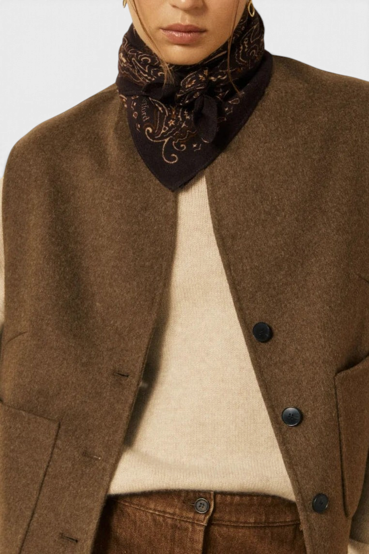 The Copper Shed paisley bandana in dark brown wool worn around the neck by a model in a brown wool vest
