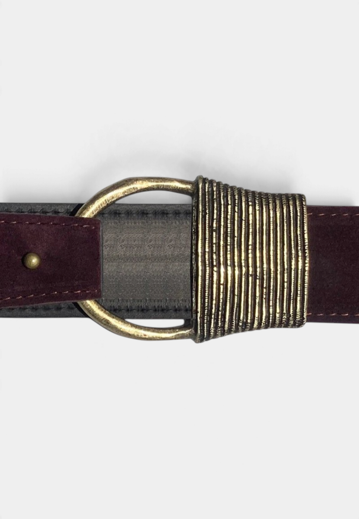 The Copper Shed Cast Rope Belt in deep burgundy suede with a textured antique brass buckle detail