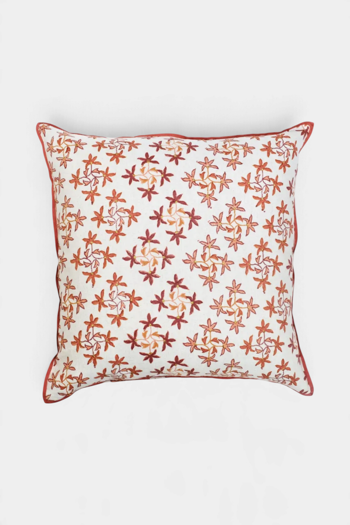 The Copper Shed Celeste pillow featuring an ombre floral motif with embroidered centers on a white background