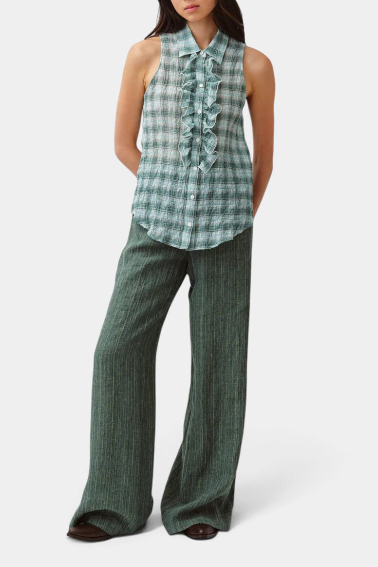 The Copper Shed Cheka Chemise sleeveless shirt in green plaid cotton with a ruffled jabot and button-front closure.