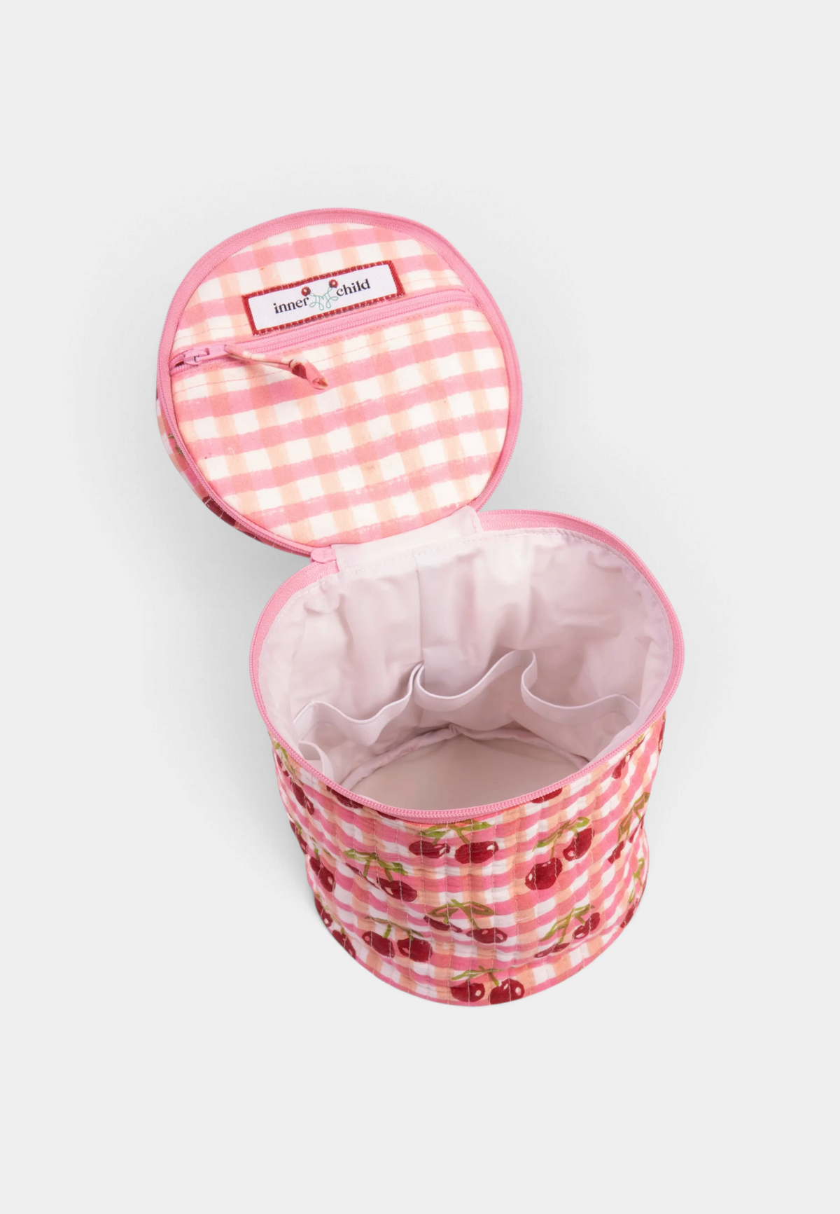 The Copper Shed round makeup bag in pink cherry print cotton with a wipeable liner and internal storage pockets.