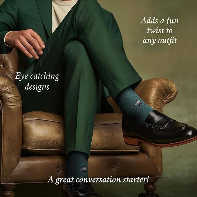 The Copper Shed novelty socks featuring a coach design, worn with a green suit and black loafers in a leather chair.