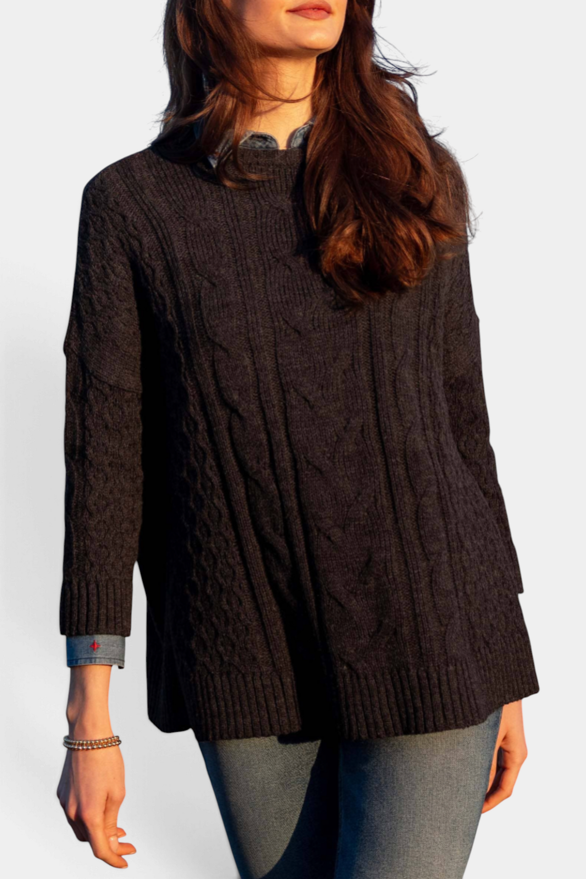 The Copper Shed Cotswold cable-knit sweater in dark charcoal with a relaxed fit and bracelet sleeves on a model