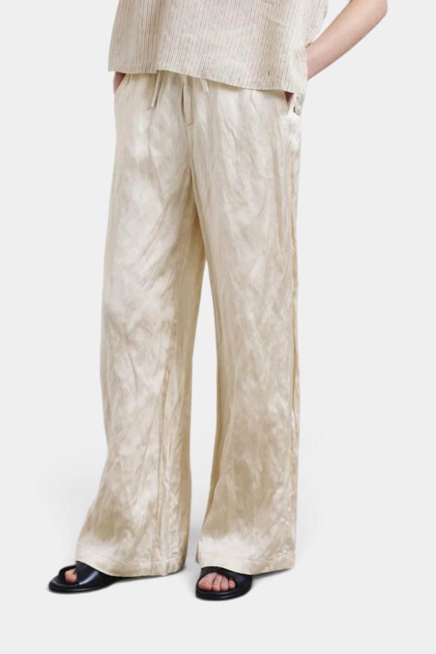 The Copper Shed crinkled viscose satin pants in champagne with an elastic waistband and wide-leg fit.