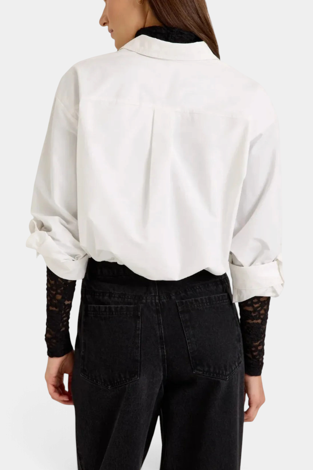 The Copper Shed Dallas Top in white cotton with a cropped bubble hem and adjustable sleeves worn over a black top.