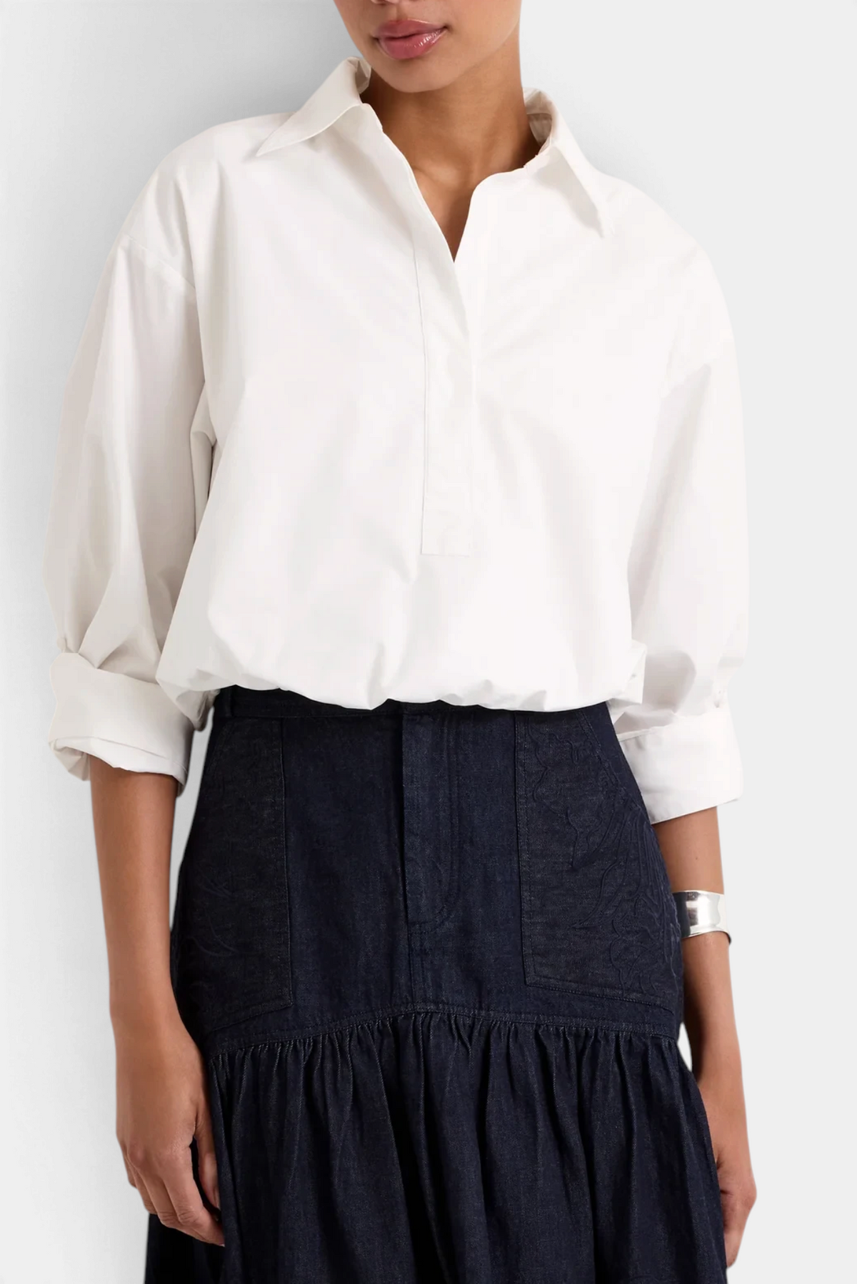 The Copper Shed Dallas white cotton shirt with a cropped silhouette, bubble hem, and adjustable sleeves on a model.
