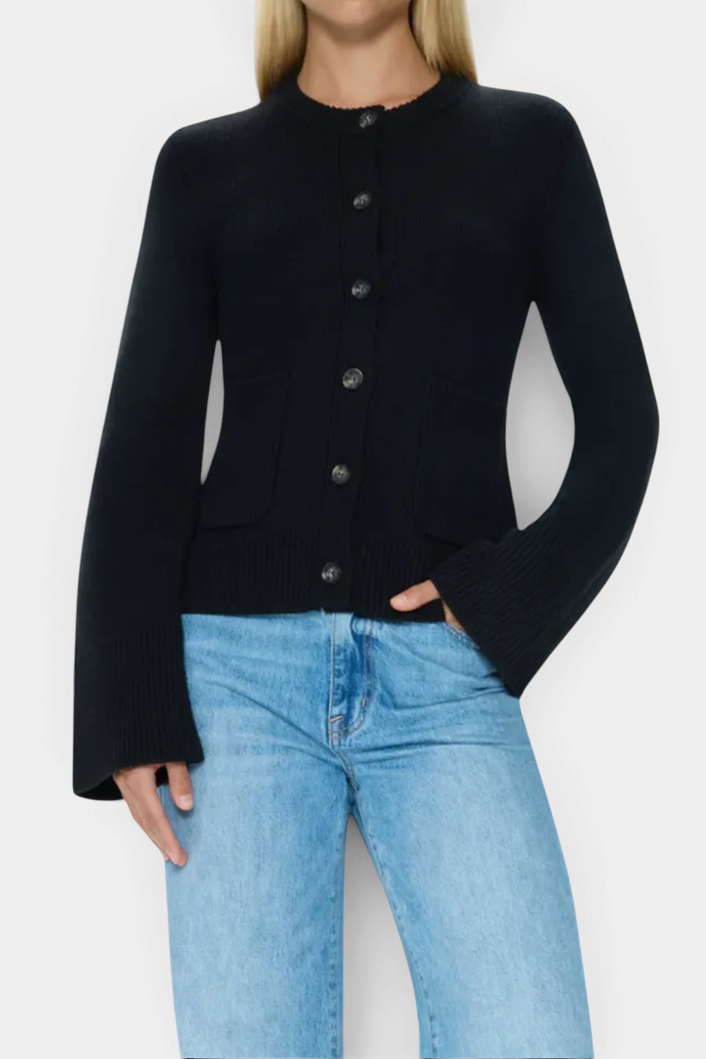 The Copper Shed Dani cardigan in noir black with a button-front, cinched waist, and flared sleeves.