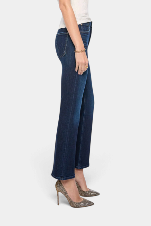 The Copper Shed high-rise dark blue flare jeans with seamed details, worn with patterned heels in a side view.
