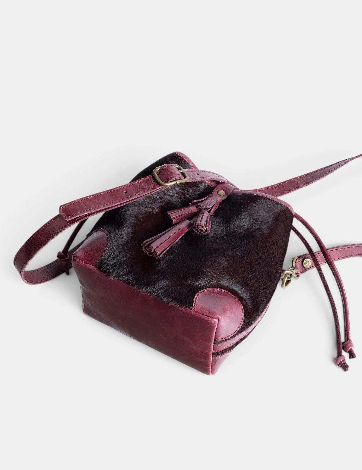 The Copper Shed dark cherry long-haired pony cowhide Fortune Teller bag with leather tassel and adjustable strap.
