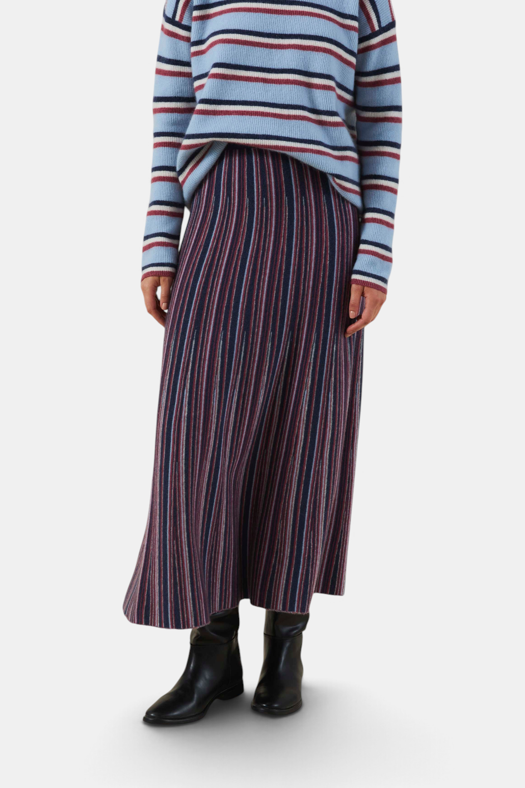 The Copper Shed Desiree08 midi skirt in a multi-colored vertical striped knit fabric worn with a striped sweater.