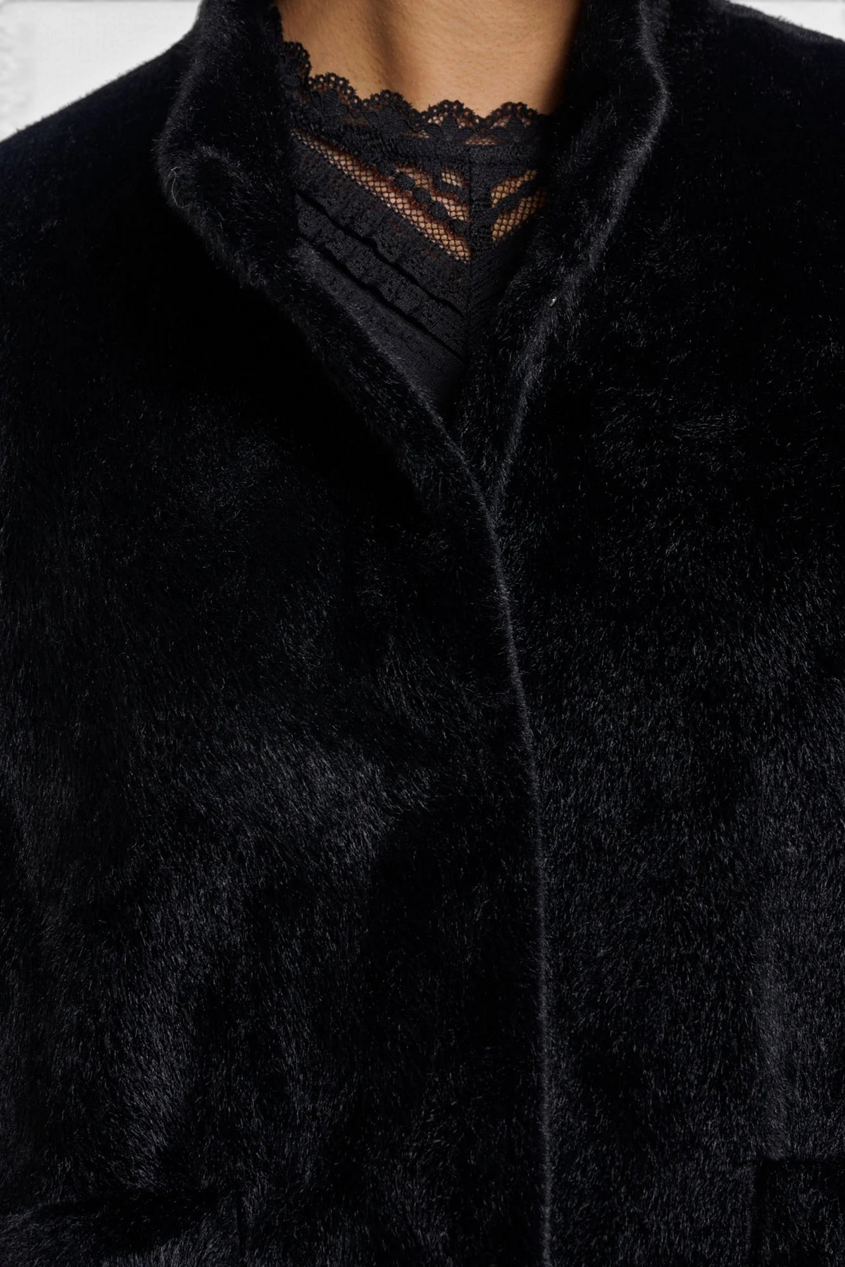 The Copper Shed Dewi Cape in soft black faux fur with a button-up front and elegant high collar detail.