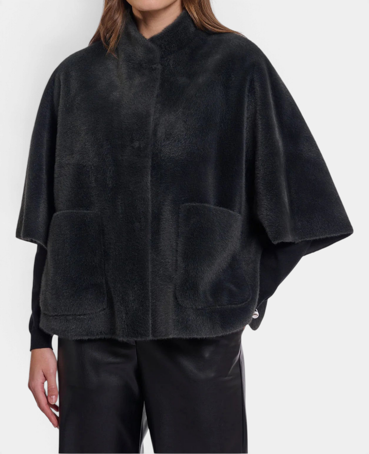 The Copper Shed Dewi cape in dark grey faux fur with a relaxed silhouette, short sleeves, and front patch pockets.
