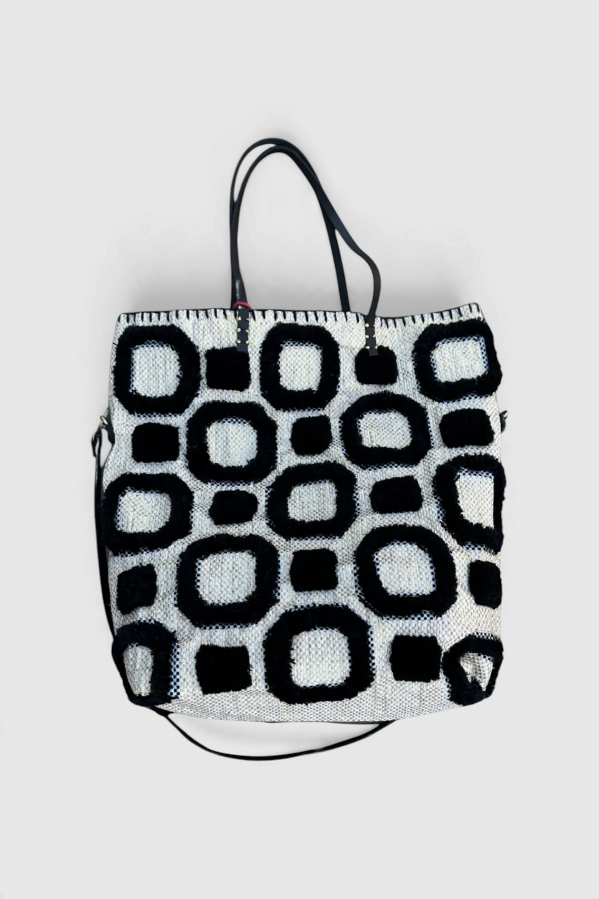 The Copper Shed En Shallah tote bag featuring a black and white geometric pattern with textured wool-like detailing.
