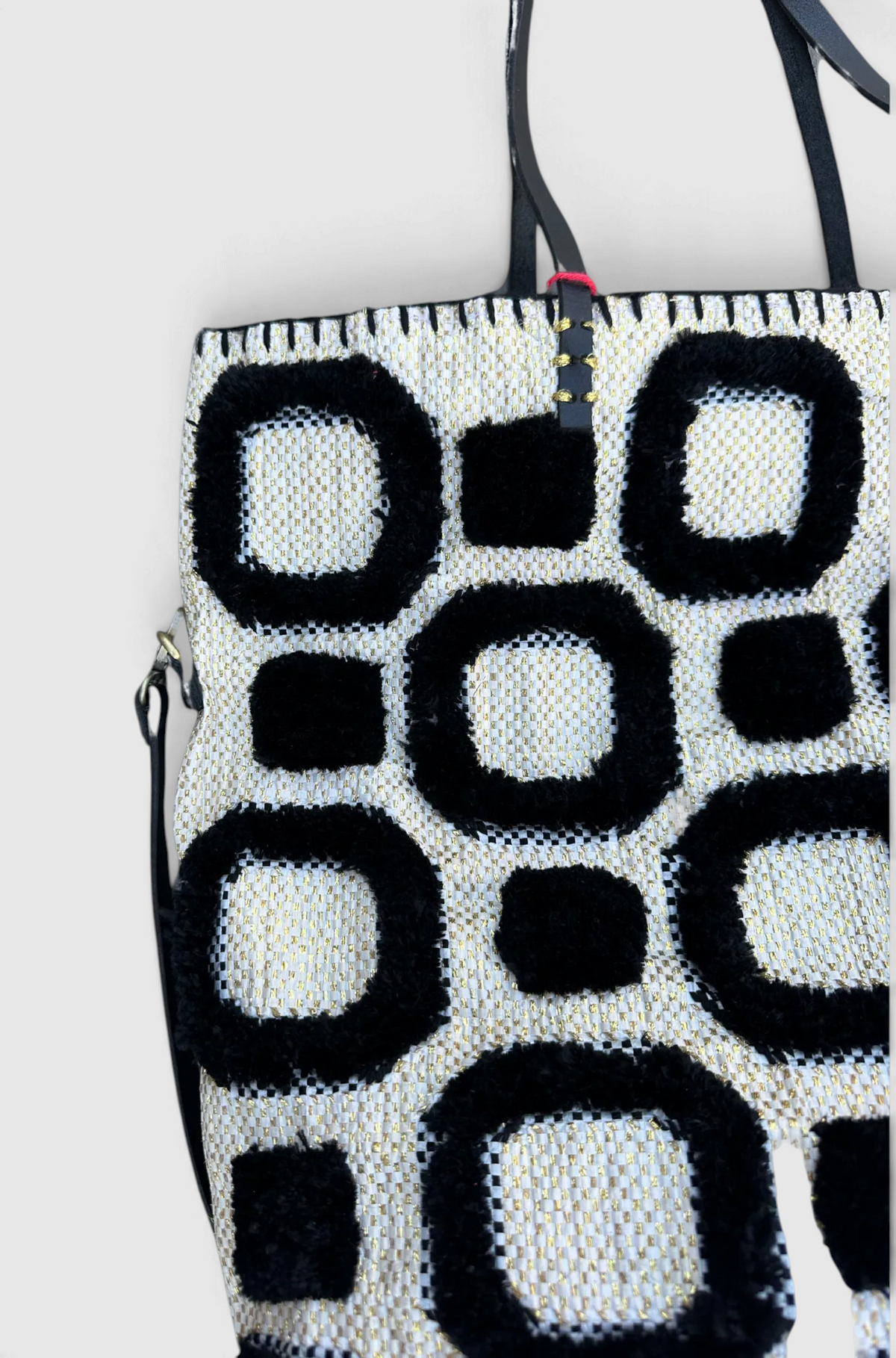 The Copper Shed En Shallah tote bag featuring a black and white geometric woven pattern with metallic gold accents.