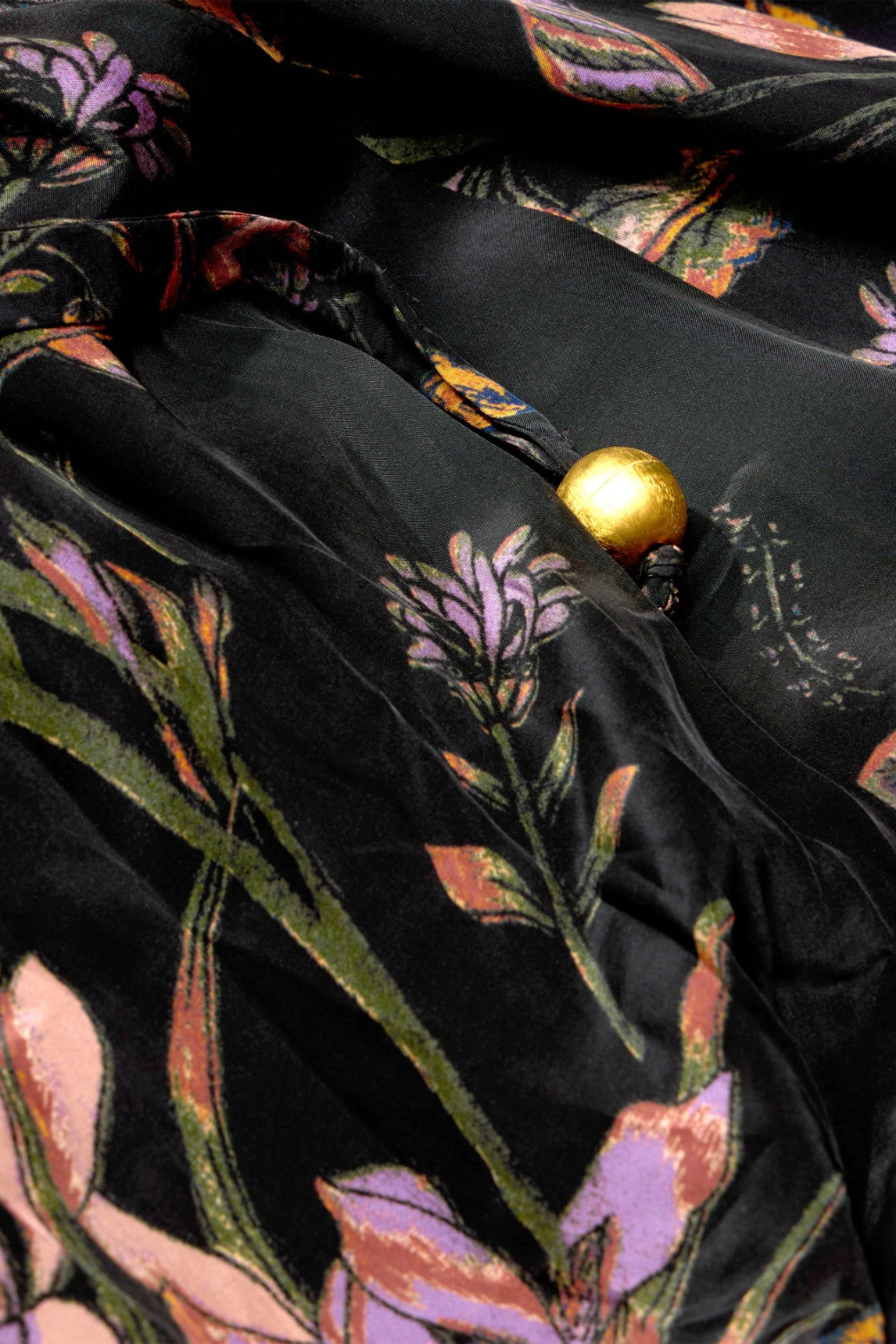 The Copper Shed Everette wrap dress in navy viscose with a floral print and a gold spherical button detail.