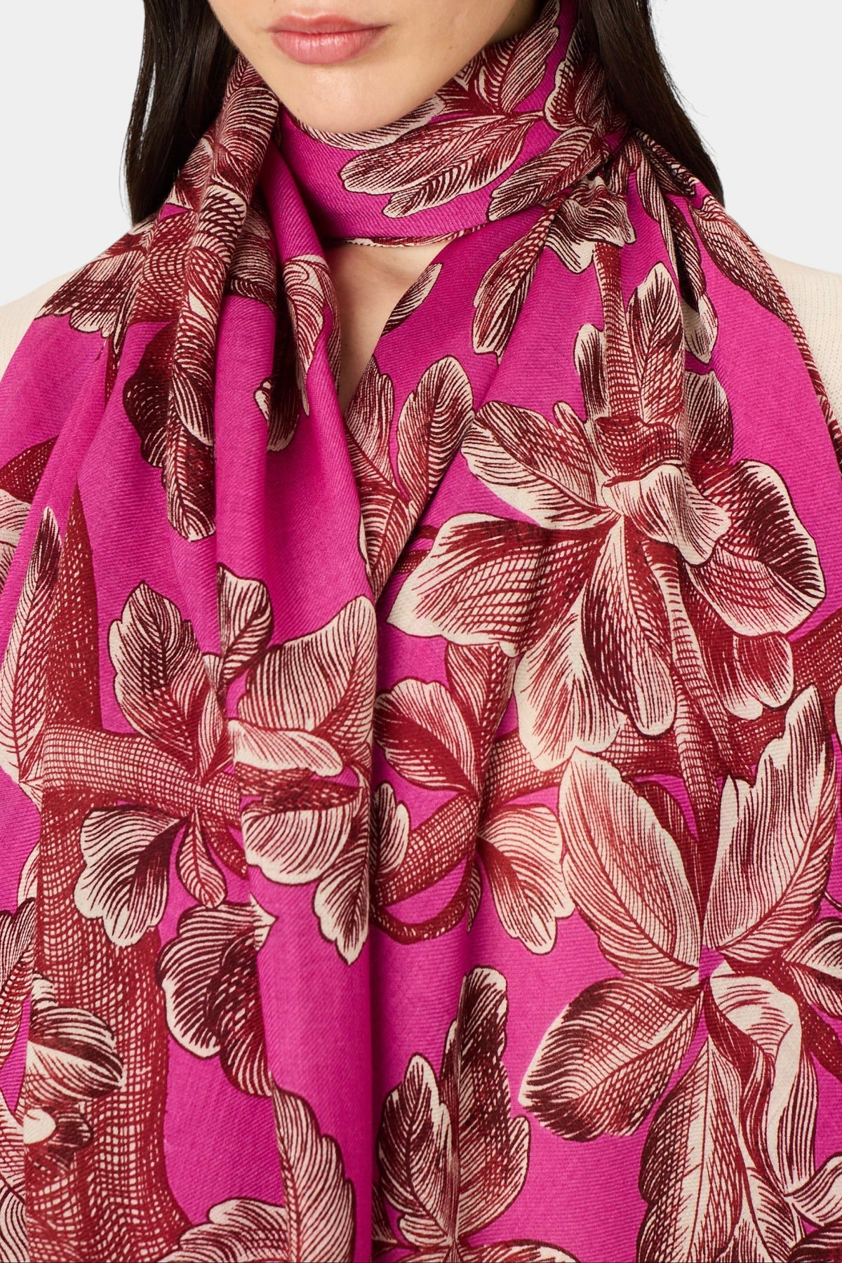 The Copper Shed Arboris scarf in fuchsia wool with a detailed dark brown botanical leaf print worn around the neck