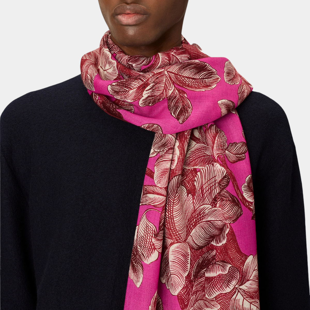 The Copper Shed Arboris fuchsia wool scarf with a detailed floral print worn around a model's neck.