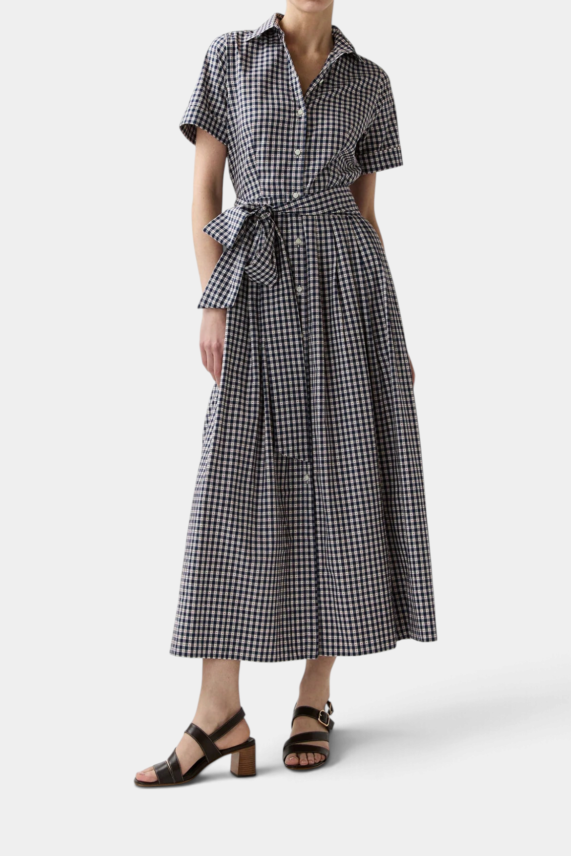 The Copper Shed shirtwaist maxi dress in navy and white embroidered gingham cotton with a self-belt and pleated skirt.