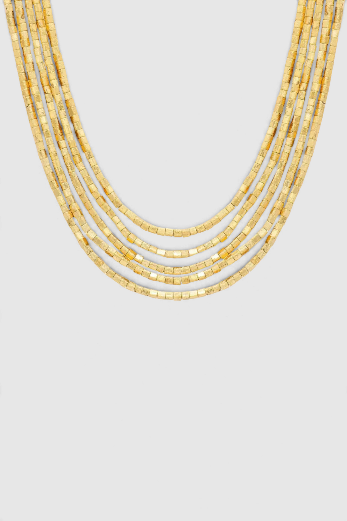 The Copper Shed Amunet 18k gold-plated multi-strand necklace featuring tiny cubic beads and a magnetic closure.