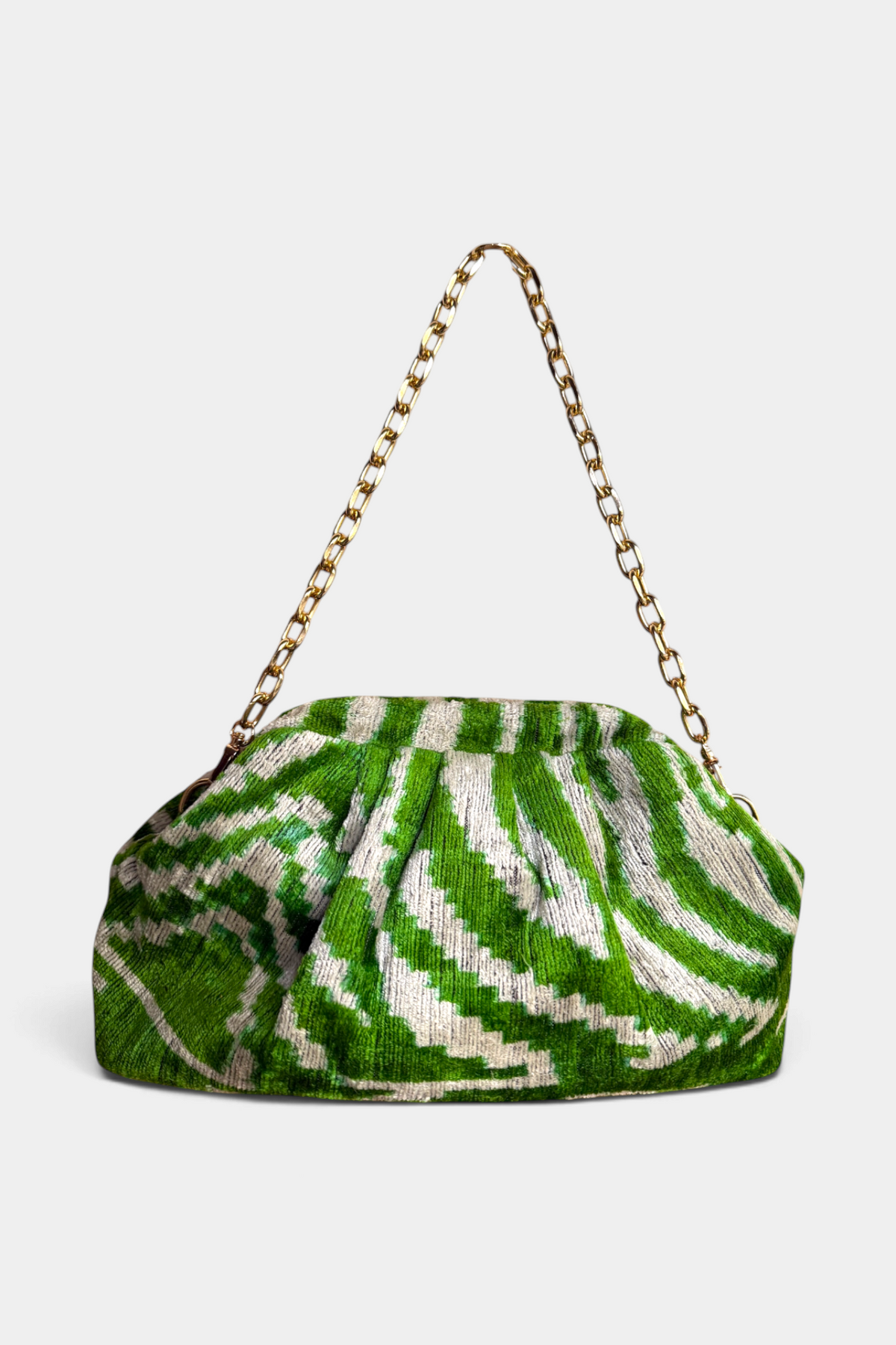 The Copper Shed handmade green and white silk velvet ikat dumpling clutch with a gold metal chain strap.