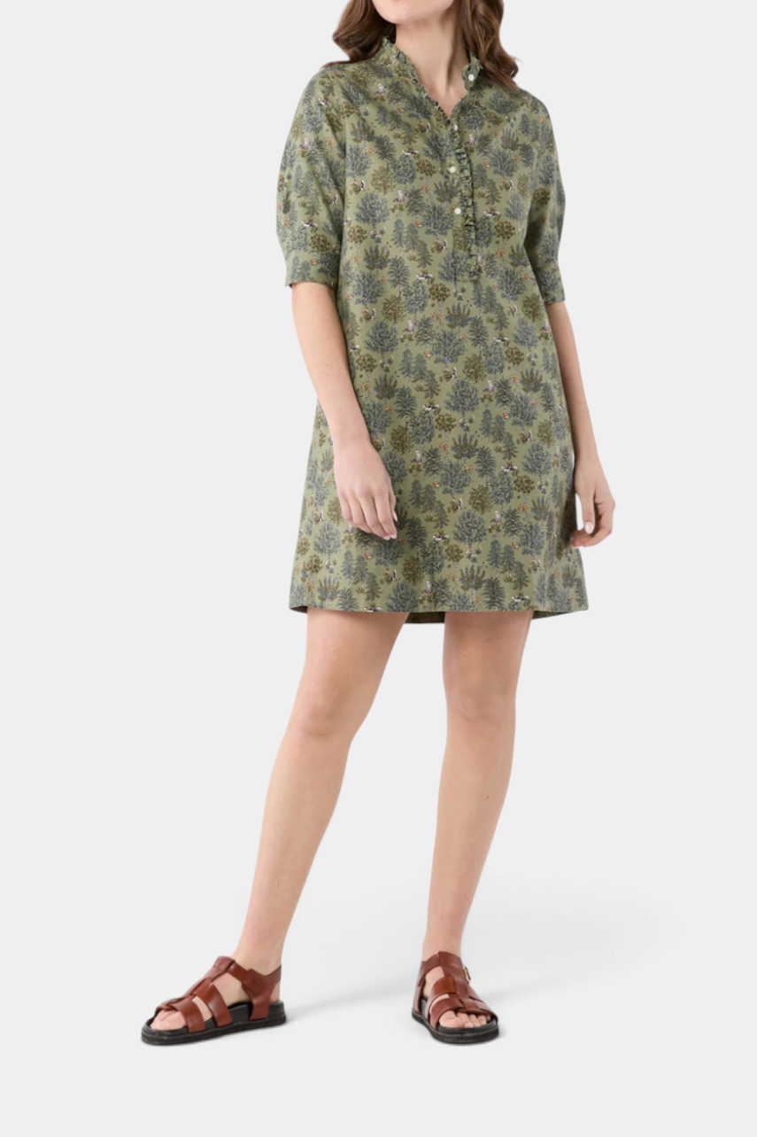 The Copper Shed elbow-sleeve frill dress in green Liberty cotton with a forest print and shell button placket.