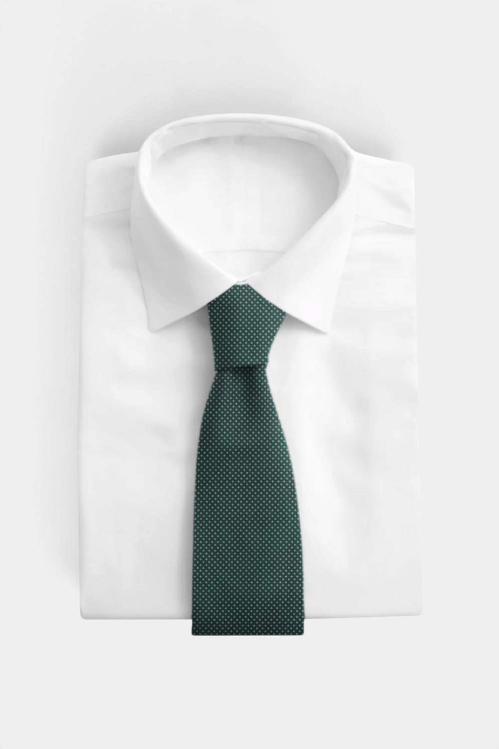 The Copper Shed woven silk neck tie in dark green with a subtle white polka dot pattern on a white dress shirt
