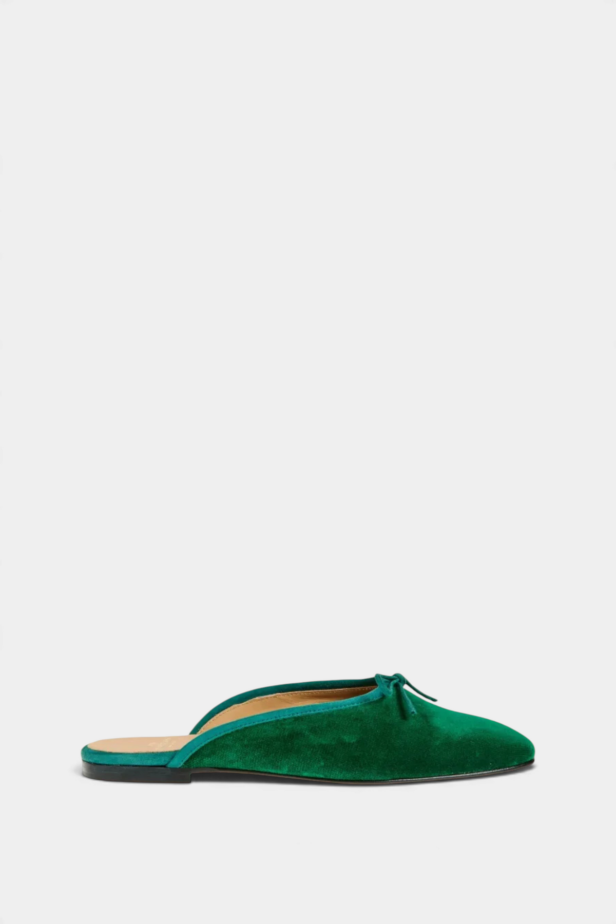 The Copper Shed Joy Mule in emerald green velvet with suede trim and a delicate bow detail on a flat leather sole.