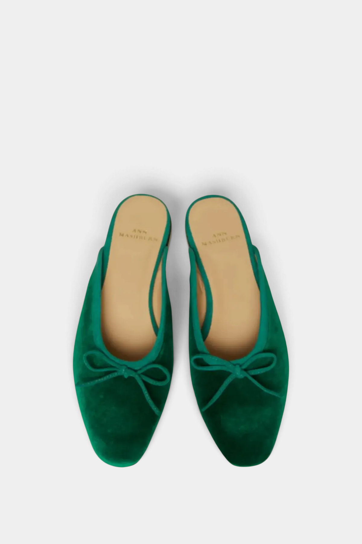 The Copper Shed Joy Mule in emerald green velvet with a delicate suede bow and cushioned leather insole