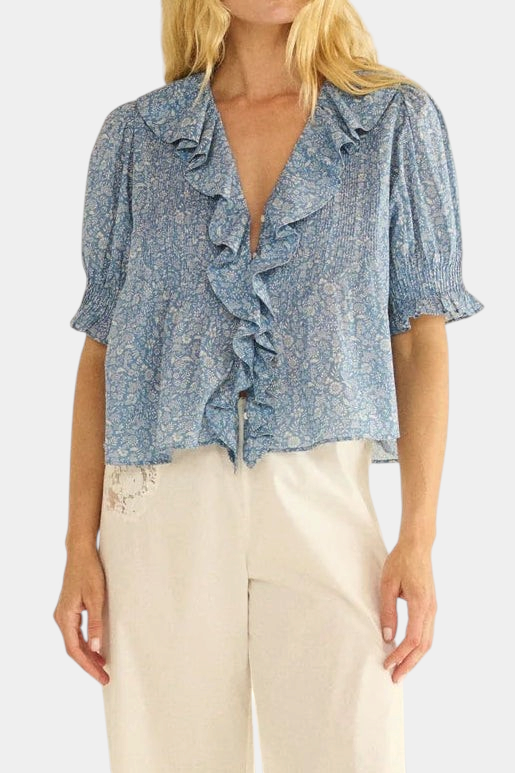 The Copper Shed Henri Top in blue floral organic cotton voile with a ruffled V-neck and puffed sleeves.