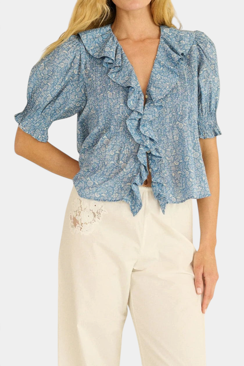The Copper Shed Henri Top in blue floral organic cotton voile with ruffled V-neck, pintucks, and puffed sleeves.